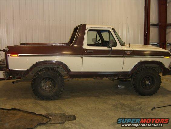 Side view of a two-tone brown and white 1978 Ford Bronco with aftermarket wheels