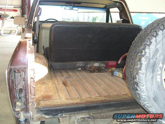1979 Ford Bronco interior cargo area with rear seat and spare tire mounted on the side