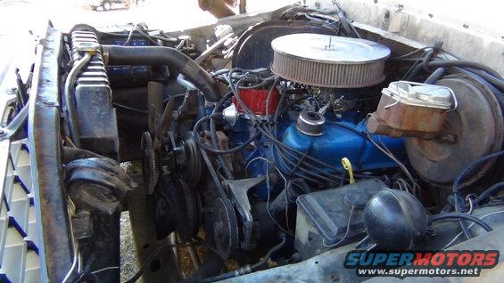 1979 Ford Bronco engine bay with blue V8 engine, air cleaner, radiator, and brake booster