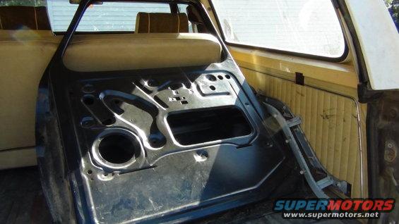 Interior of a vehicle door, showing the bare metal frame and some of the interior paneling