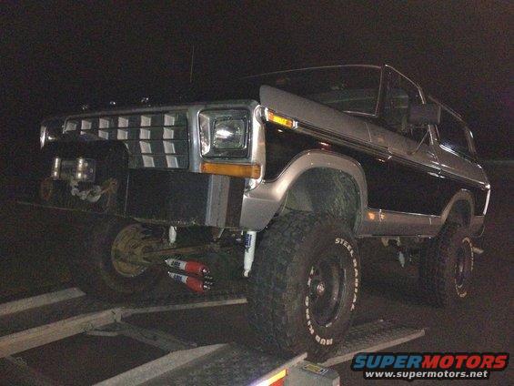 Ford Bronco on a trailer, front end visible. It has a chrome grille and large tires