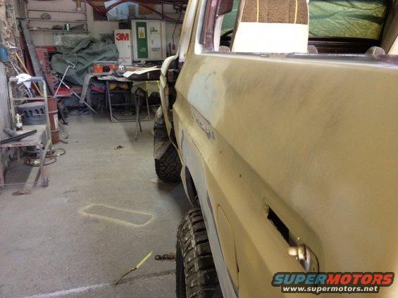 Side view of a 1979 Ford Bronco being worked on in a garage