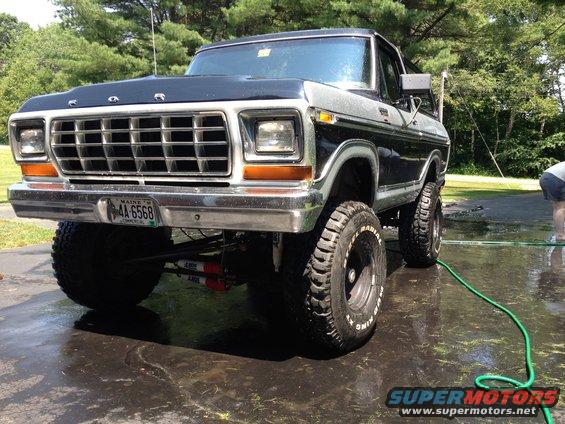 Black and silver 1979 Ford Bronco with lifted suspension and large tires, front view