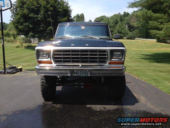 Front view of a dark blue Ford Bronco with a chrome grille and a Maine license plate