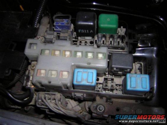Close-up of a car's fuse box with multiple relays and fuses