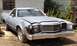 1975 Ford Ranchero - This damaged 1977 Ford Ranchero sits in a junkyard, its front end showing significant wear and tear.