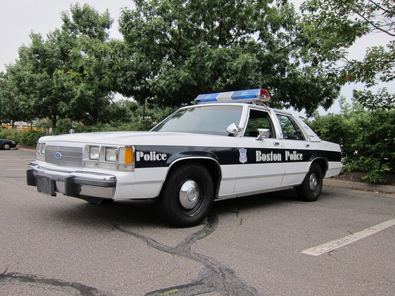Boston Police car, white with black stripe and 'Boston Police' text. Light bar on top