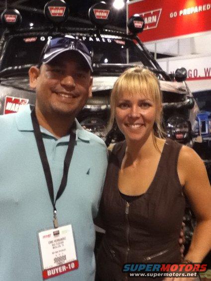 Man and woman posing in front of a vehicle equipped with multiple WARN brand lights on a roof rack