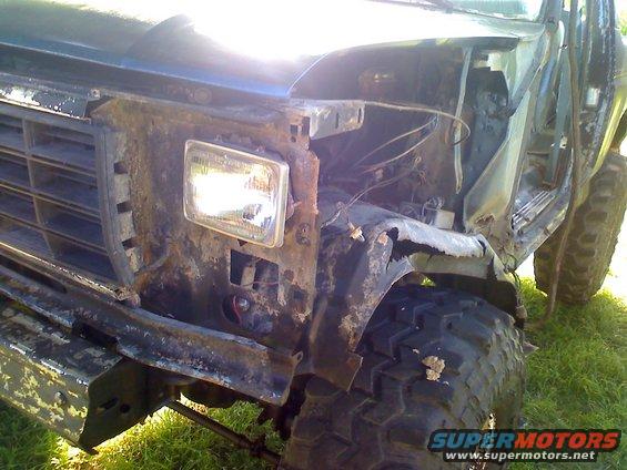 Rusted 3q-front view of a 1990 Ford Bronco with damaged front end