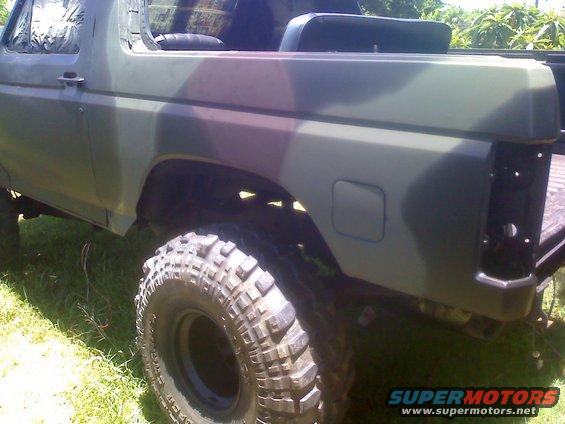 Camouflaged SUV side view with large off-road tires