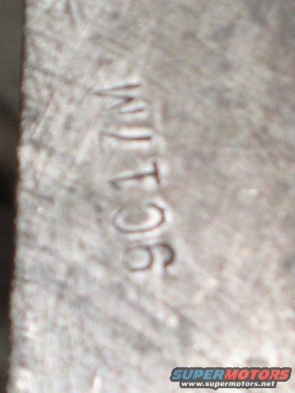 Close-up of a metal part with stamped numbers 'WJ T 96'