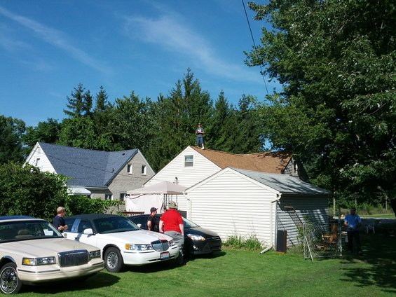 White sedan with black vinyl top parked in a grassy yard