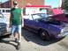 1970 Ford Ranchero - A man stands beside a purple 1970 Dodge Challenger convertible at an outdoor car show.