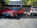 1970 Ford Ranchero - A vintage red coupe with distinctive hood scoops is parked next to a modern SUV.