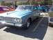 1970 Ford Ranchero - A light blue 1964 Plymouth Fury coupe is parked in a lot next to other vehicles.