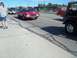 1970 Ford Ranchero - A red 1970 Ford Ranchero is seen driving on a sunny day, with other vehicles and pedestrians present.