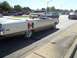 1970 Ford Ranchero - A white convertible with a Hurst logo drives down a street with other cars.
