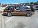 1970 Ford Ranchero - This brown station wagon features wood paneling and custom wheels, with its hood open.