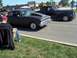 1970 Ford Ranchero - A man sits in a lawn chair watching two vintage cars drive by on a sunny day.