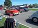 1970 Ford Ranchero - An orange convertible off-road vehicle is parked on the street, with other cars and spectators in the background.