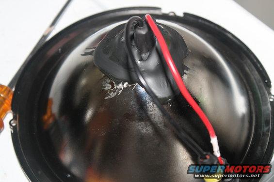 Headlight assembly with red and black wires attached