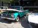 1970 Ford Ranchero - Turquoise and white pickup truck with hood open, showing its 1965 grille and parked next to a white sports car.