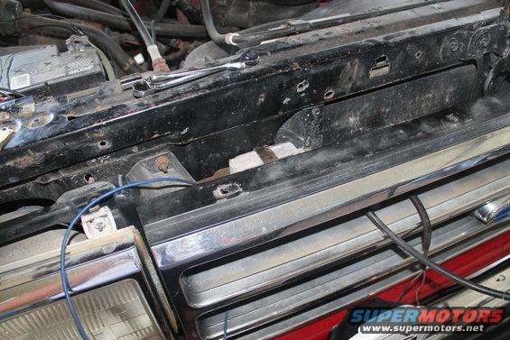 1990 Ford Bronco grille and engine bay with wiring and battery visible