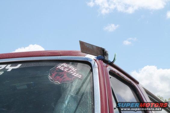 Red vehicle roofline with a metal cleaver mounted on a bracket