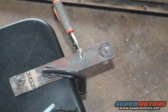 metal bracket clamped to black surface, being welded