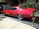 1970 Ford Ranchero - This red 1970 Ford Torino GT features a distinctive gold stripe along its side and a partially open hood.