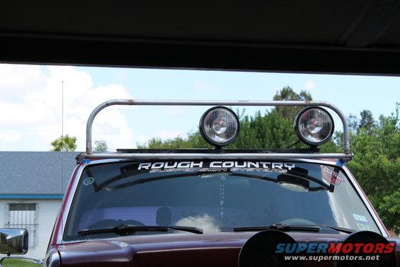 1990 Ford Bronco front view with roof-mounted light bar and two off-road lights. 'ROUGH COUNTRY' sticker visible on windshield