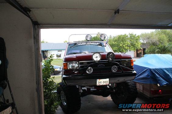 Red 1990 Ford Bronco front view with light bar and off-road lights