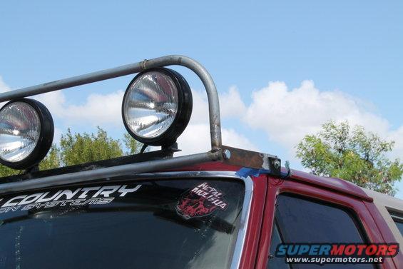 Red SUV roof with light bar and spotlights. "COUNTRY" and "METAL MULISHA" stickers visible