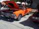 1970 Ford Ranchero - An orange El Camino is displayed with its hood up, parked on a street next to another vehicle.