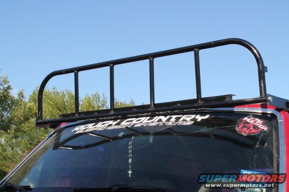 Black metal roof rack mounted on a red vehicle's windshield frame