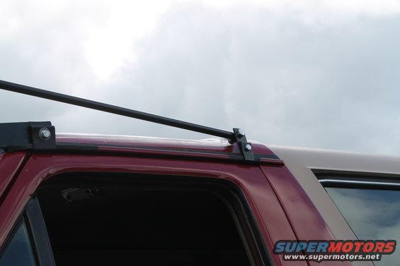 Close-up of a roof rack mounted on a red SUV's roofline