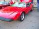 1970 Ford Ranchero - Red sports car parked on asphalt, with another vehicle visible behind it.