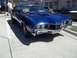 1970 Ford Ranchero - A blue coupe sits on a paved lot with a 'For Sale' sign in the window.