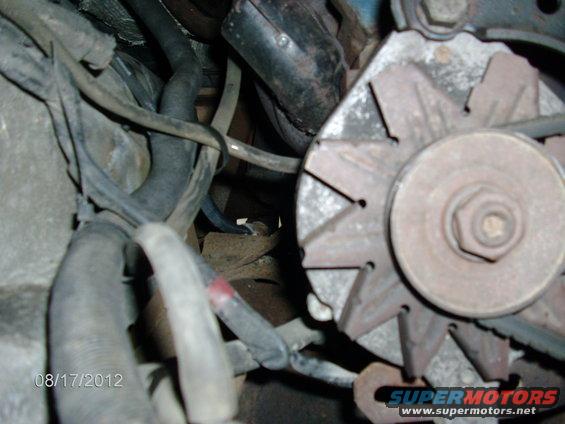 Close-up of an alternator and engine hoses with a date stamp of 08/17/2012