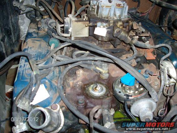 Close-up of an engine bay, showing the carburetor, distributor, and various hoses. Date stamp '08/17/2012' visible