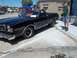 1970 Ford Ranchero - A black 1970 Ford Ranchero is parked on a street with a man standing nearby and an orange 'For Sale' sign visible in the window.