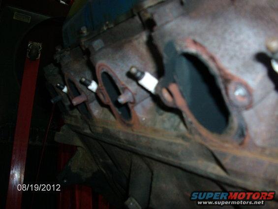 Engine block with spark plugs installed in exhaust ports