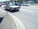 1970 Ford Ranchero - A classic gold Pontiac GTO cruises down a street with other vehicles and tents visible.