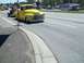 1970 Ford Ranchero - A bright yellow pickup truck from the 1950s tows a trailer down a suburban street.