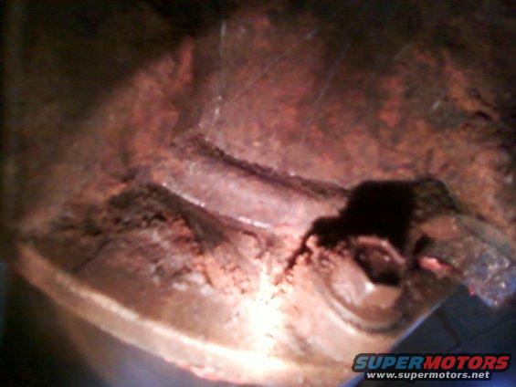 rusted metal part showing a crack and debris