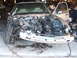 1966 Ford Ranchero - The front of a tan car is disassembled, revealing the engine and surrounding components.