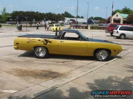 Yellow 1972 Ford Ranchero with a black hood and bed cover, custom dragon decal on the side, and chrome wheels