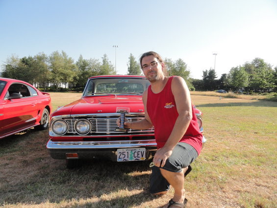 Red 1960s sedan front view with horizontal grille and dual headlights