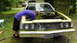 1973 Ford Torino - A man works on the engine of a 1973 Ford Torino, with another car visible in the background.