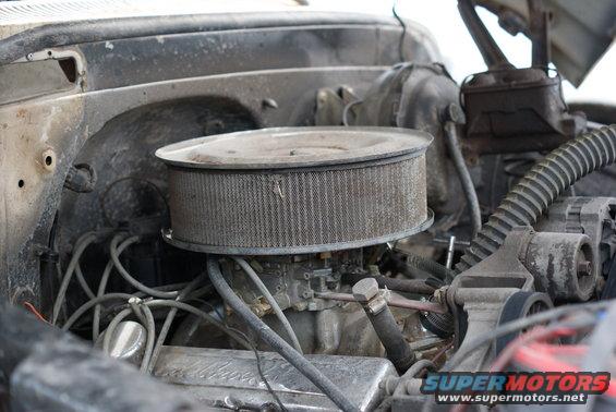 Engine bay with air filter and carburetor visible